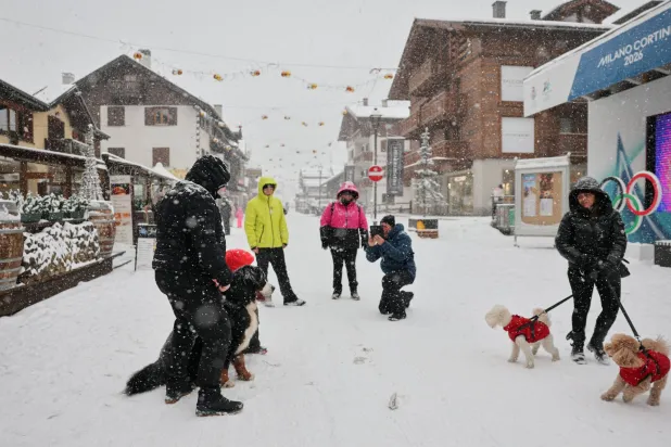 أشخاص يتنزهون مع كلابهم في ليفينيو، إيطاليا 8 يناير 2026 (رويترز)

