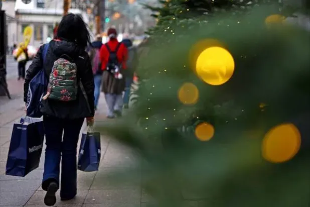 متسوقون خارج متجر «كاوفهاوس ديس ويستنس» خلال موسم عيد الميلاد في برلين (رويترز)