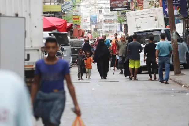 يمنيون يسيرون في سوق بمدينة عدن (إ.ب.أ)