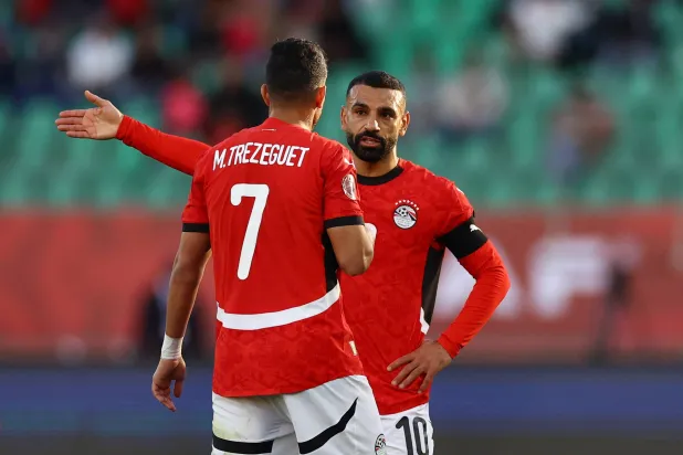 تريزيغيه يتحدث مع صلاح خلال مباراة بنين (رويترز)