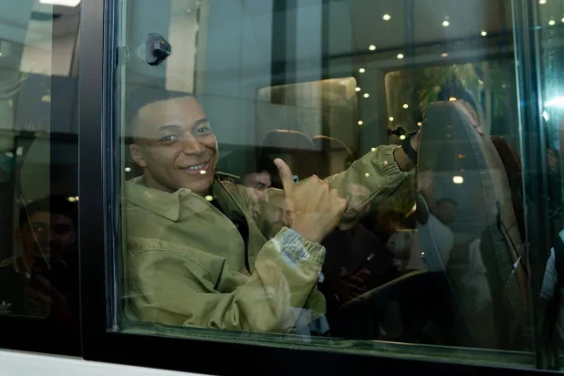 مبابي يشير للكاميرا من على متن السيارة التي أقلته إلى فندق البعثة (وزارة الرياضة)