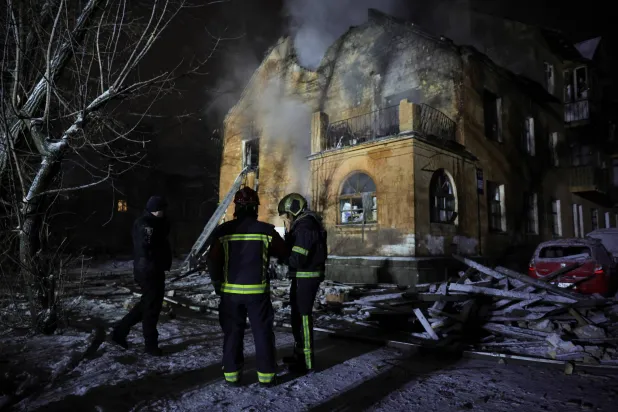 إطفائيان في محيط مبنى أصيب بالضربات الجوية الروسية على كييف (رويترز)