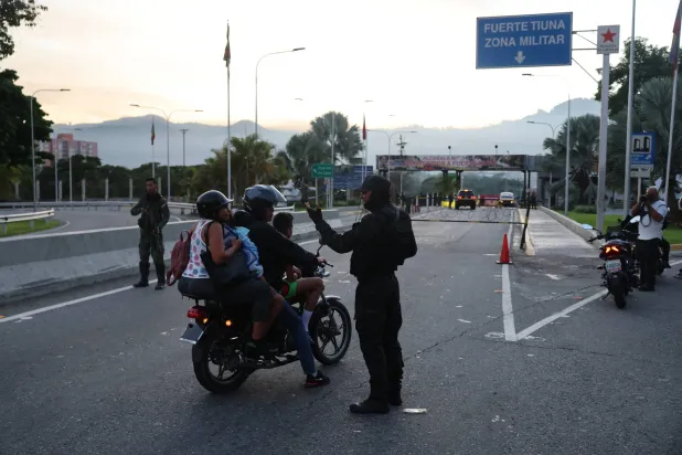 People go through a checkpoint near Fuerte Tiuna (Fort Tiuna), which houses the headquarters of Venezuelan Ministry of Defense, in Caracas, Venezuela, 03 January 2026, after multiple explosions were reported across the capital. EPA/MIGUEL GUTIERREZ
