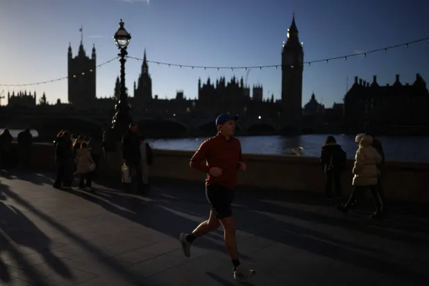 عدّاء يركض تحت أشعة الشمس في ظهيرة باردة بلندن (أ.ف.ب)