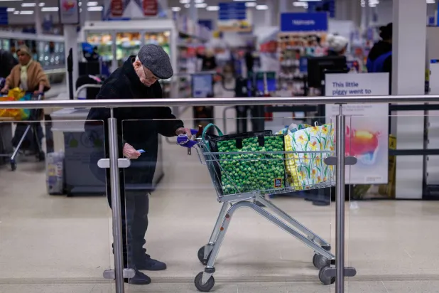 شخص مسن يغادر متجراً في شرق لندن (إ.ب.أ)