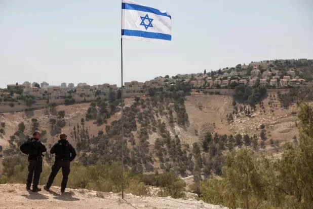 The Israeli flag, with part of the Israeli settlement of Ma’ale Adumim visible in the background in the occupied West Bank on August 14, 2025. (Reuters) 