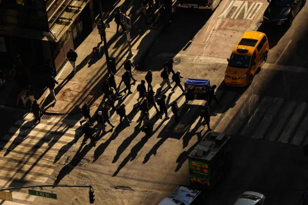 Pedestrians and cars move along Lexington Avenue in the Manhattan borough of New York City on December 16, 2025. (Photo by CHARLY TRIBALLEAU / AFP)