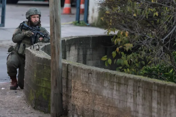 جندي إسرائيلي يتخذ موقعه خلال عملية عسكرية حول البلدة القديمة لمدينة نابلس شمال الضفة الغربية المحتلة يوم الأحد (أ.ف.ب)