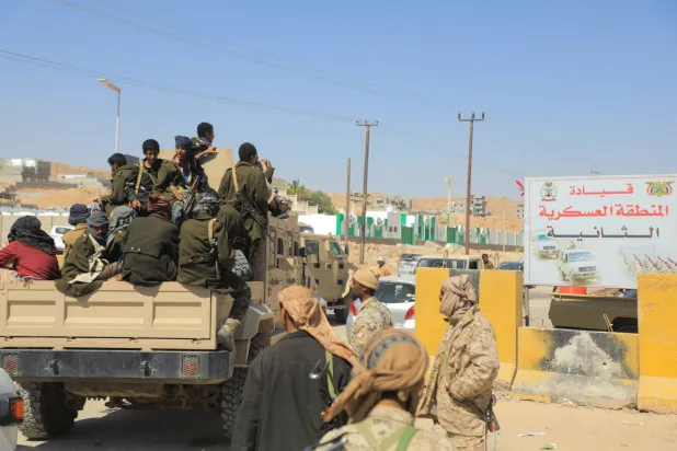 جنود حكوميون على ظهر مركبة عسكرية في مدينة المكلا الساحلية كبرى مدن حضرموت شرق اليمن (رويترز)