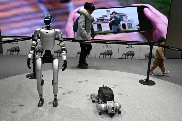 زوار يمرون بجوار الروبوتات المعروضة في أول متجر بيع بالتجزئة (أ.ف.ب)