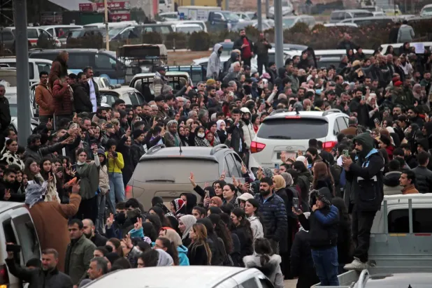 Halep’in kuzeyinden SDG savaşçılarını taşıyan araçların etrafında toplandı (AFP)