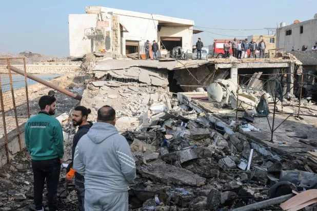 سكان يتفقدون الأضرار الناتجة عن غارات إسرائيلية استهدفت المنطقة الصناعية في صيدا عاصمة جنوب لبنان (إ.ب.أ)