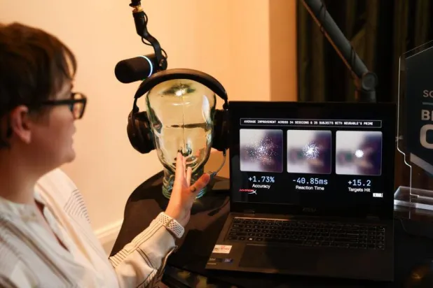 Neurable research scientist Alicia Howell-Munson demonstrates the company's headset, which it says can detect early signs of Alzheimer's disease. Patrick T. Fallon / AFP
