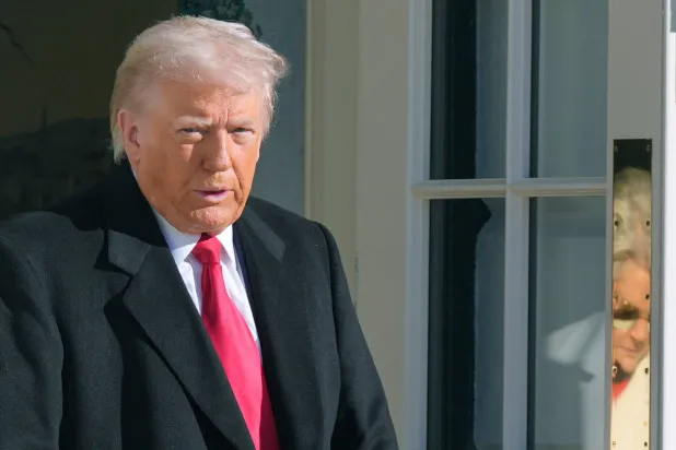  President Donald Trump and White House Chief of Staff Susie Wiles, reflected on door, leave to board Marine One, Tuesday, Jan. 13, 2026, in Washington. (AP) 