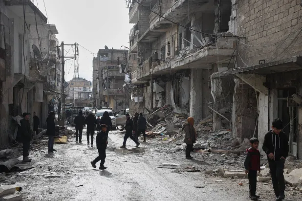 سوريون يتفقدون الأضرار التي لحقت بالأبنية في حي الشيخ مقصود بحلب بعد الاشتباكات الأخيرة (أ.ب) 
