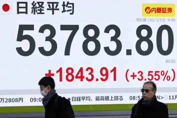 مشاة يمرون أمام شاشة إلكترونية تعرض حركة الأسهم في وسط العاصمة اليابانية طوكيو (أ.ب)