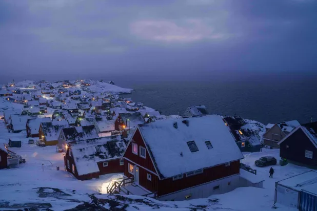 Houses covered by snow are seen on the coast of a sea inlet of Nuuk, Greenland, on Monday, Jan. 12, 2026. (AP)