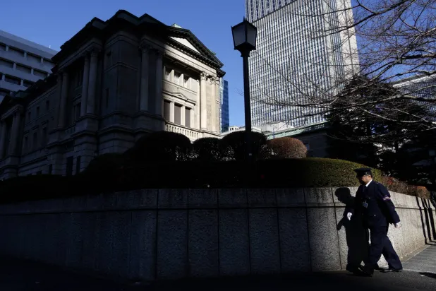 رجل أمن يمر حول السور الخارجي لمقر البنك المركزي في العاصمة اليابانية طوكيو (إ.ب.أ)