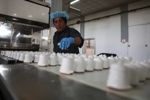 A Palestinian employee inspects sweet locally known as "al-Shatwi" (Winter) Crimbo sweets, as the Al-Arees factory gradually resumes operations after a hiatus caused by the Gaza war which led to shortages of raw materials used in their products, in Deir al-Balah, in the central Gaza Strip on January 12, 2026, following a US-brokered truce that halted the two-year war. (AFP)