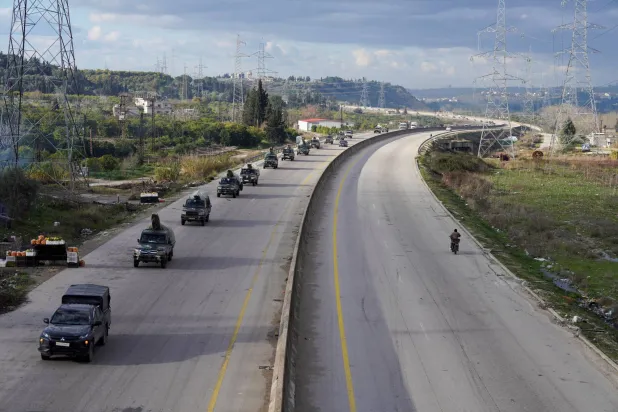 Military vehicles drive along a road as the last Kurdish-led Syrian Democratic Forces (SDF) fighters left the Syrian city of Aleppo on Sunday, state-run Ekhbariya TV said, following a ceasefire deal that allowed evacuations after days of deadly clashes, in Latakia, Syria, January 14, 2026. (Reuters)