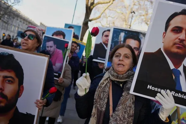  Protesters hold up placards with pictures of victims as they demonstrate in support of anti-government protests in Iran, outside Downing Street, in London, Wednesday, Jan. 14, 2026. (AP) 