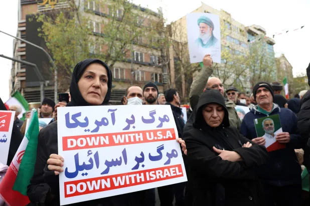 Mourners hold anti-US and anti-Israeli placards during a funeral ceremony for security personnel killed during anti-government protests, in Tehran, Iran, 14 January 2026. (EPA)