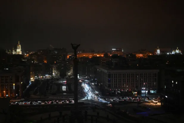 سيارات تسير في ساحة الاستقلال خلال انقطاع التيار الكهربائي في كييف في 14 يناير 2026 وسط الغزو الروسي لأوكرانيا (أ.ف.ب)