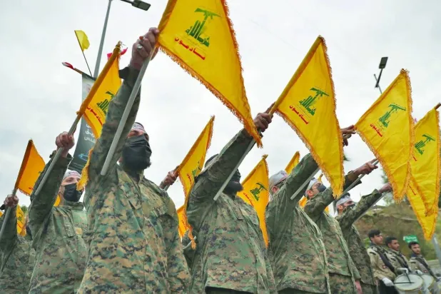 Hezbollah members take an oath in front of a monument to Iranian General Qassem Soleimani in Beirut in 2022 (AP file photo)  