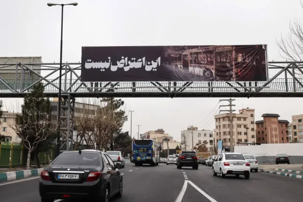 Tahran'da dün "Bu bir protesto değil" yazılı pankart taşıyan arabalar sokaklarda dolaştı (AFP)