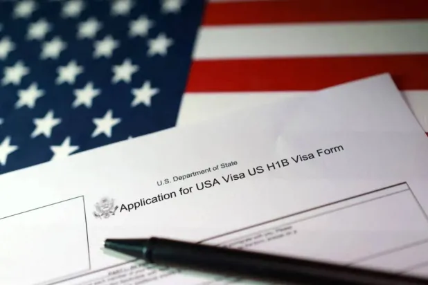 A US flag and a US H-1B Visa application form are seen in this illustration taken, September 22, 2025. REUTERS/Dado Ruvic/Illustration 