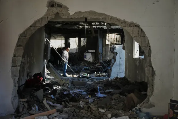 فلسطيني يعلين الدمار الذي خلفته ضربة إسرائيلية في منزل بدير البلح وسط قطاع غزة أمس (أ.ب)