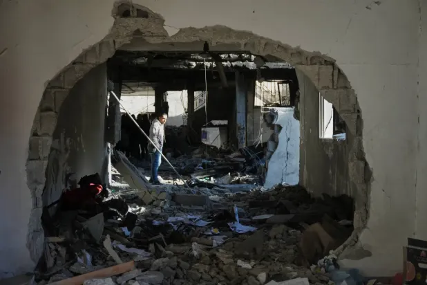 Bir Filistinli, dün Gazze Şeridi'nin merkezindeki Deyr el-Belah'ta bir eve düzenlenen İsrail saldırısının yol açtığı yıkımı gösteriyor (AP)