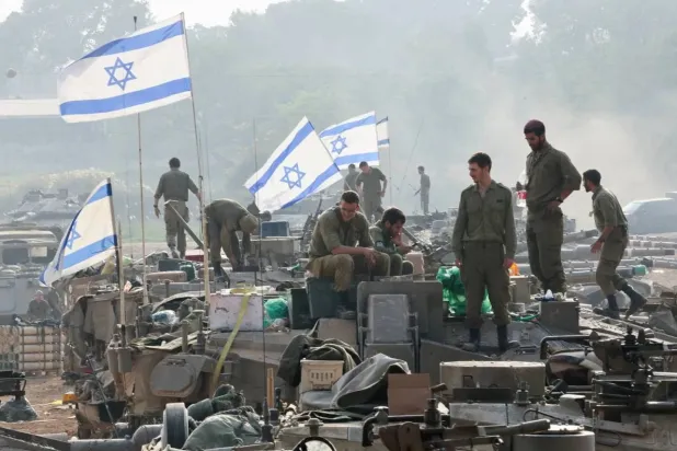 Israeli soldiers stand on tanks, amid the conflict between Israel and Hamas, near the Israel-Gaza border, in southern Israel, January 1, 2024. REUTERS/Violeta Santos Moura/File Photo