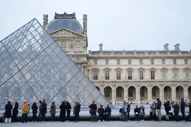 FILE - People wait for the Louvre museum to open, Thursday, Dec. 18, 2025 in Paris. (AP Photo/Thibault Camus, File)