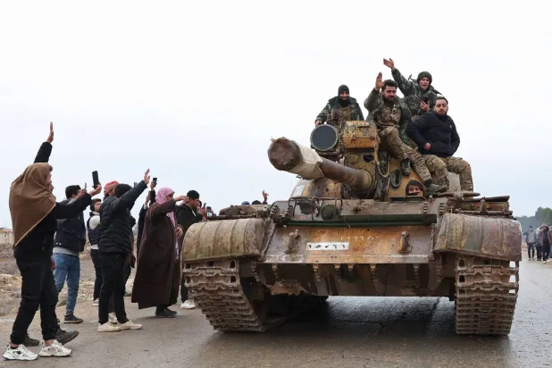 جنود سوريون يدخلون على ظهر دبابة مدينة مسكنة في ريف حلب الشرقي بعد انسحاب قوات «قسد» منها أمس (أ.ف.ب)