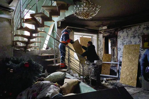 شخصان داخل مبنى سكني استهدفته غارة روسية في خاركيف شمال شرقي أوكرانيا الأحد (إ.ب.أ)