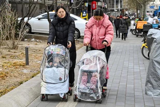  Women push baby strollers as they walk along a street in Beijing on January 4, 2026. (AFP)