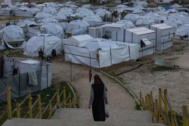 سيدة فلسطينية أمام خيام مؤقتة أقيمت بمدينة خان يونس جنوب قطاع غزة (إ.ب.أ)