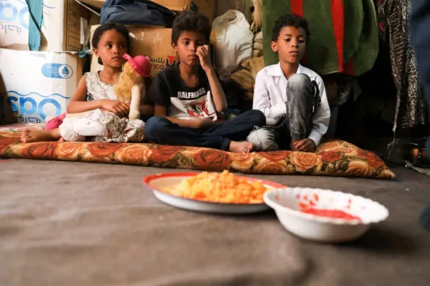 Children wait for lunch at their hut in Sanaa, Yemen August 29, 2022 (Reuters)