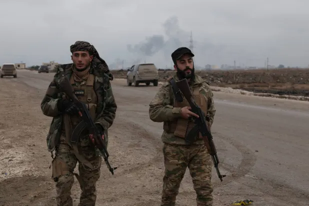 عنصران من القوات الحكومية السورية في الرقة الأحد (أ.ف.ب)