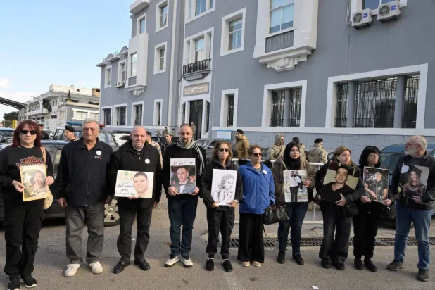 أهالي الضحايا يرفعون صور أبنائهم الذين قُتلوا في انفجار مرفأ بيروت يوم 4 أغسطس 2020 (الشرق الأوسط)