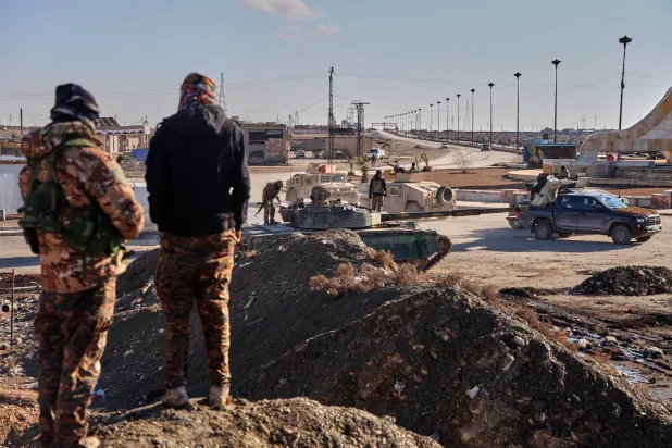 جنود من قوات سوريا الديمقراطية (قسد)  ينتشرون بمركبات عسكرية مدرعة لتأمين الطرق المؤدية إلى سجن غويران (أ.ب)