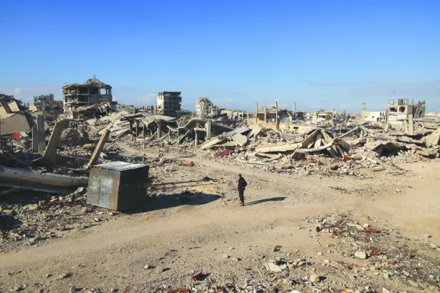 Filistinli bir adam Gazze'nin güneyindeki Han Yunus'ta ailesinin evinin yıkıntıları yakınında duruyor ve enkaz altında kalan akrabalarını aramaya devam ediyor. (Arşiv- Reuters)