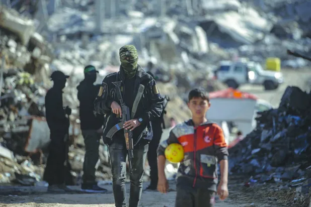 A Palestinian child is seen as fighters from Hamas’ Qassam Brigades search for the bodies of Israeli hostages in the Jabalia refugee camp in northern Gaza, last December. (EPA)