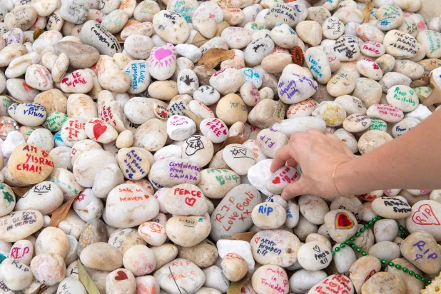A visitor places a pebble at a memorial site in remembrance to the lives lost during the Bondi Beach mass shooting on December 14, 2025, in Sydney, Australia, January 16, 2026. (Reuters)