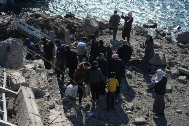 Civilians cross a collapsed bridge linking Raqqa with its western countryside of Tabqa, northern Syria, 19 January 2026. EPA/AHMAD FALLAHA