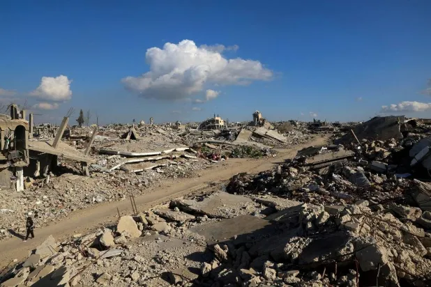 A Palestinian girl walks past the rubble of houses destroyed in Israeli strikes during the war, in Khan Younis, southern Gaza Strip, January 17, 2026. (Reuters)