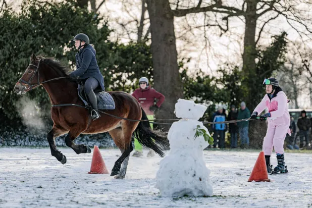 شخص يمتطي حصاناً خلال المشاركة في مسابقة على الثلج بهولندا (إ.ب.أ)