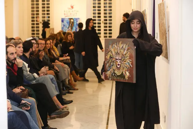 فتيات يحملن لوحات هبة الخطيب أمام الجمهور (ريبيرث بيروت)