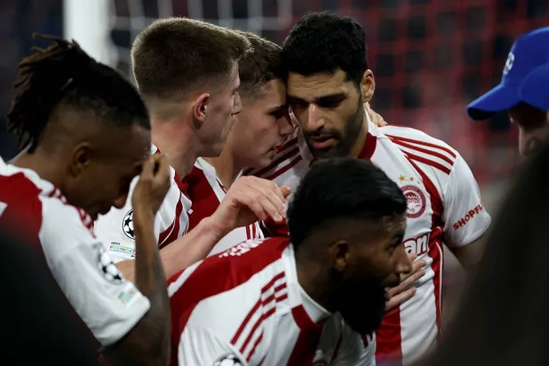 لاعبو أولمبياكوس يحتفلون بالتسجيل في مرمى ليفركوزن (إ.ب.)